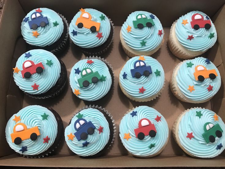 twelve cupcakes in a box with cars on them