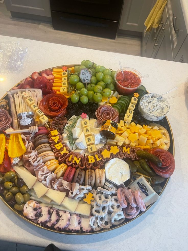 a platter filled with cheese, crackers and grapes