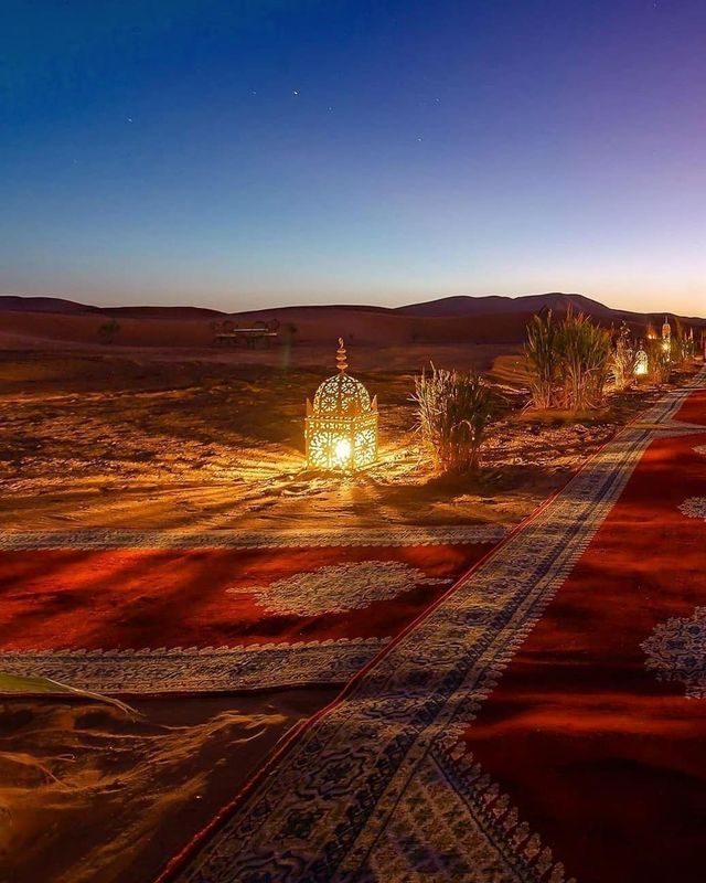 an outdoor area with many lights and rugs on the ground in front of it