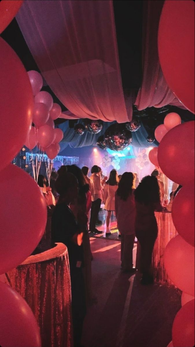 a group of people that are standing under some balloons