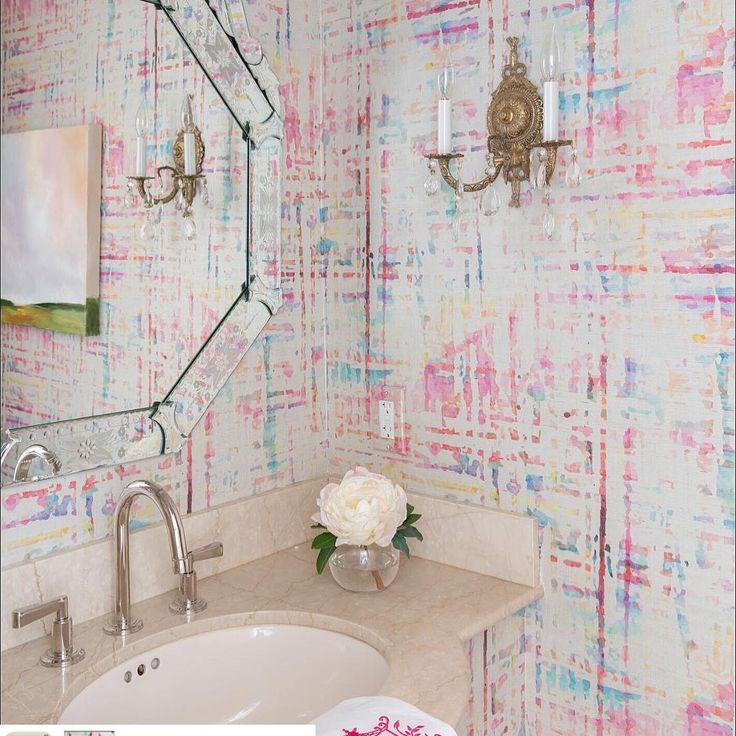 a bathroom decorated in pink, white and blue with flowers on the sink counter top