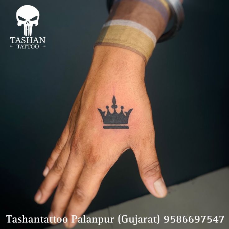 a person's hand with a crown tattoo on their left wrist and the words tahantoo palapur guarat