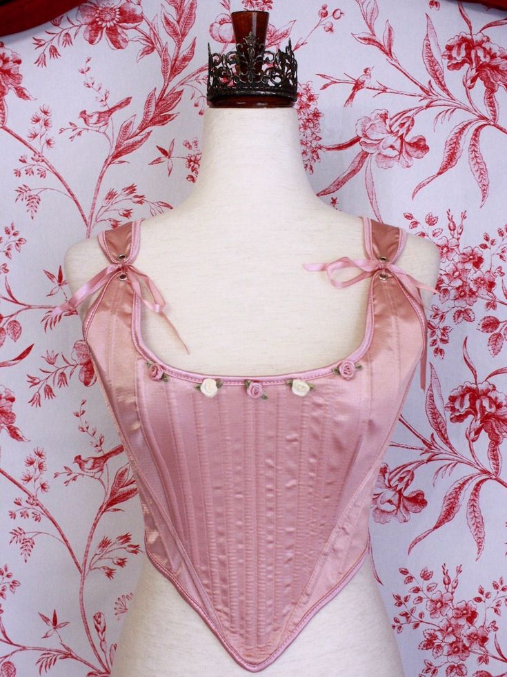 Be the star of the show with this gorgeous Renaissance to Baroque Era corset, this time in a special ballet pink satin! This piece features hand-sewn mauve and ivory rosette adornments, pink satin ribbon finishes, adjustable straps, and a classic Tudor Era design. Style it over a delicate dress or blouse with a puffy skirt for the perfect historically-inspired ballerina look. Sizing: ✧IN✧ Bust Waist S 30-34 Inches 24-28 Inches M 34-38 Inches 28-32 Inches L 38-42 Inches 30-34 Inches XL 40-44 Inches 36-40 Inches ✧CM✧ Bust Waist S 75-85 CM 60-70 CM M 85-95 CM 70-80 CM L 95-105 CM 75-85 CM XL 100-110 CM 90-100 CM Materials:10% Elastane 90% Polyester Care:Gently hand wash or dry clean only. Air dry only, hang or dry flat. Corset Stays, Baroque Era, Delicate Dress, Fantasy Shop, Tudor Era, Puffy Skirt, Ballet Pink, Rococo Style, Medieval Fashion