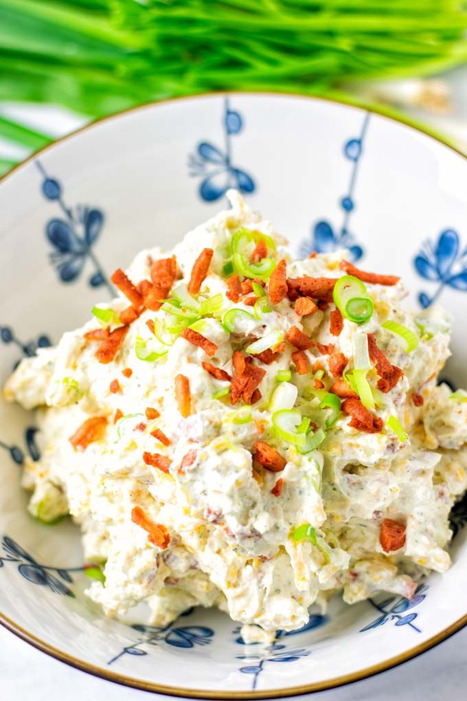 a bowl filled with coleslaw and carrots on top of a blue and white plate