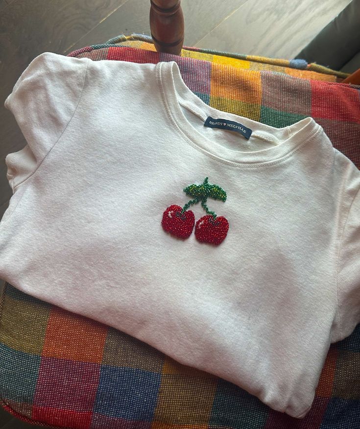 a white shirt with two cherries on it