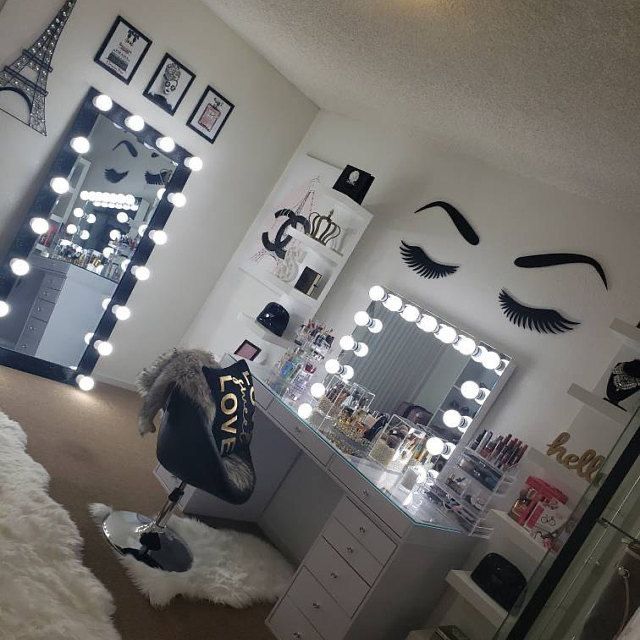 a room with many lights and mirrors on the wall, including a chair in front of a vanity