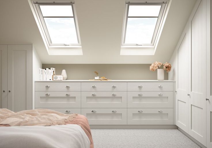 a bedroom with two skylights above the bed and dressers in front of it