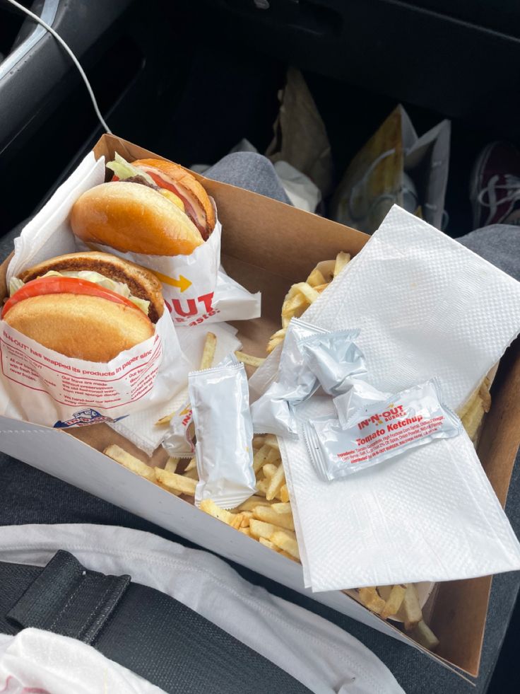 a box filled with lots of hot dogs and french fries on top of a table