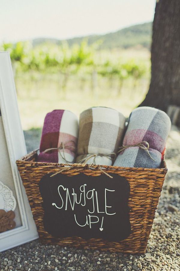 a teddy bear sitting in a basket next to a photo frame and some blankets on the ground