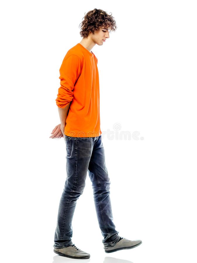 a young man in an orange shirt is walking