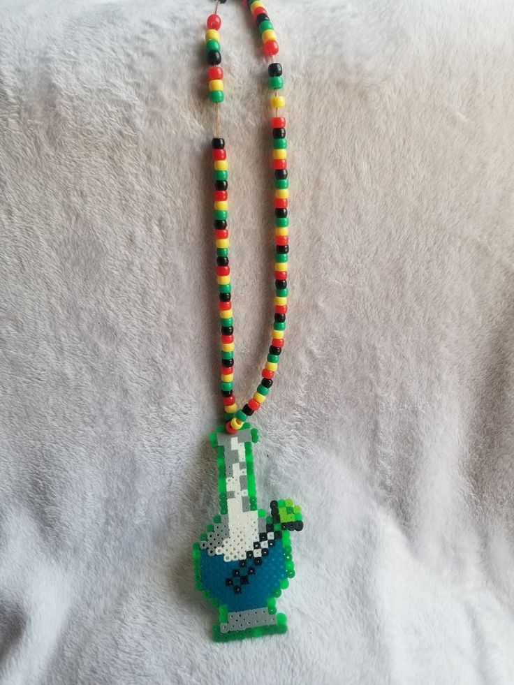 a beaded necklace with an image of a green turtle on it's side