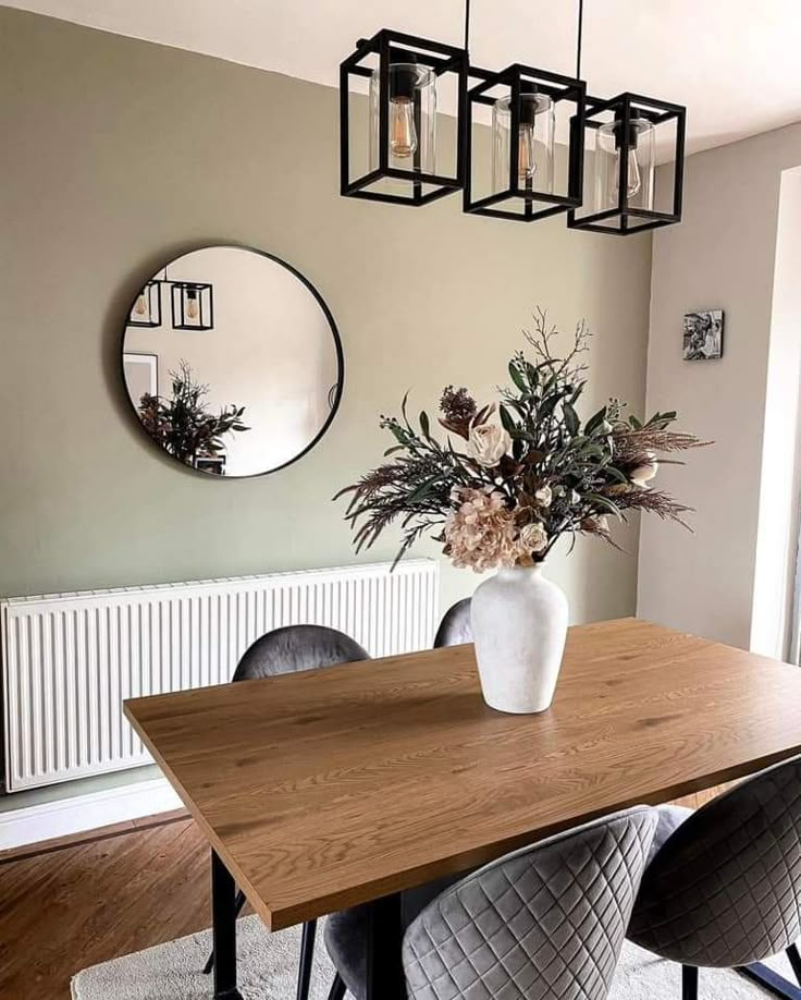 a dining room table with chairs and a vase filled with flowers on top of it