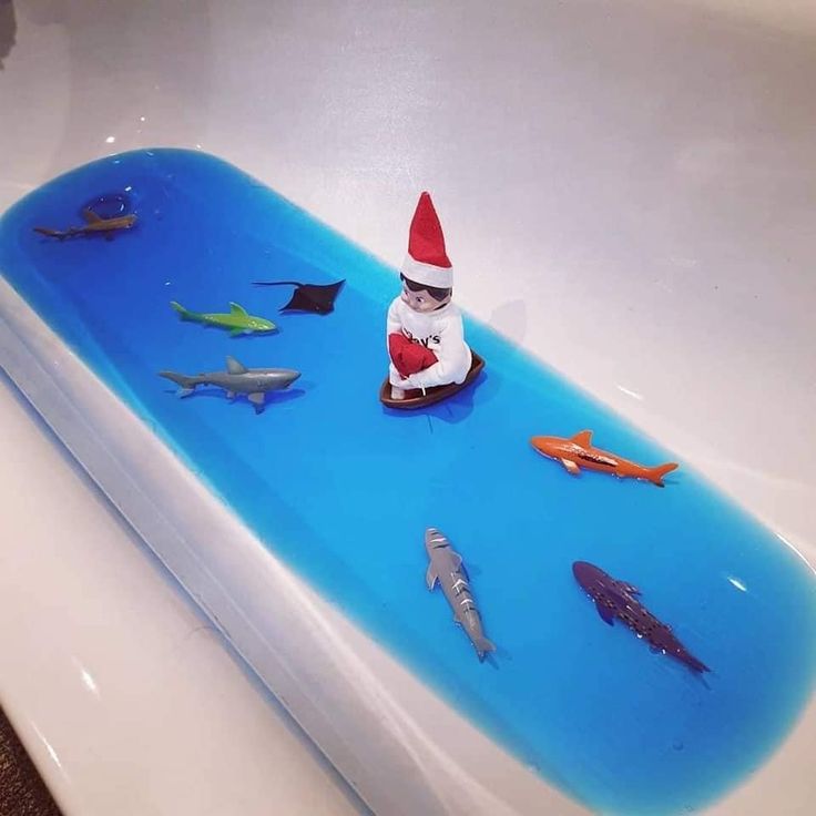 an elf sitting on top of a bath tub filled with fish