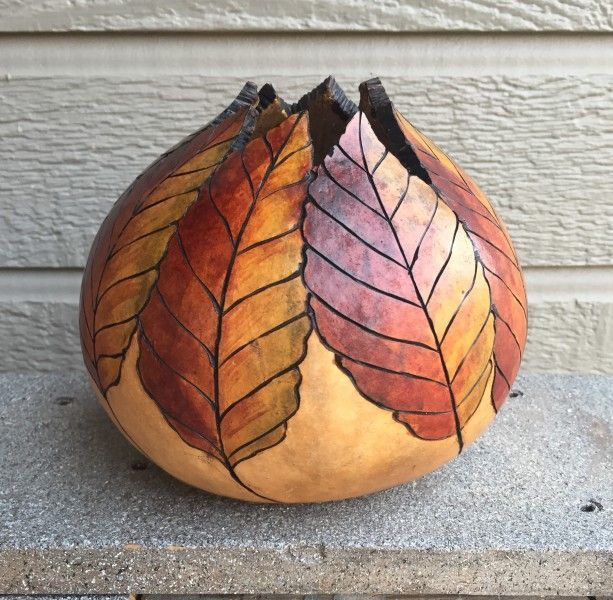 a vase with leaves painted on it