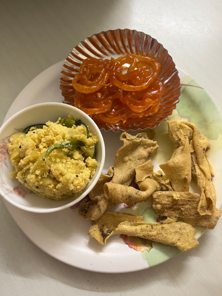 a plate with some food on it and a bowl of sauce next to it,