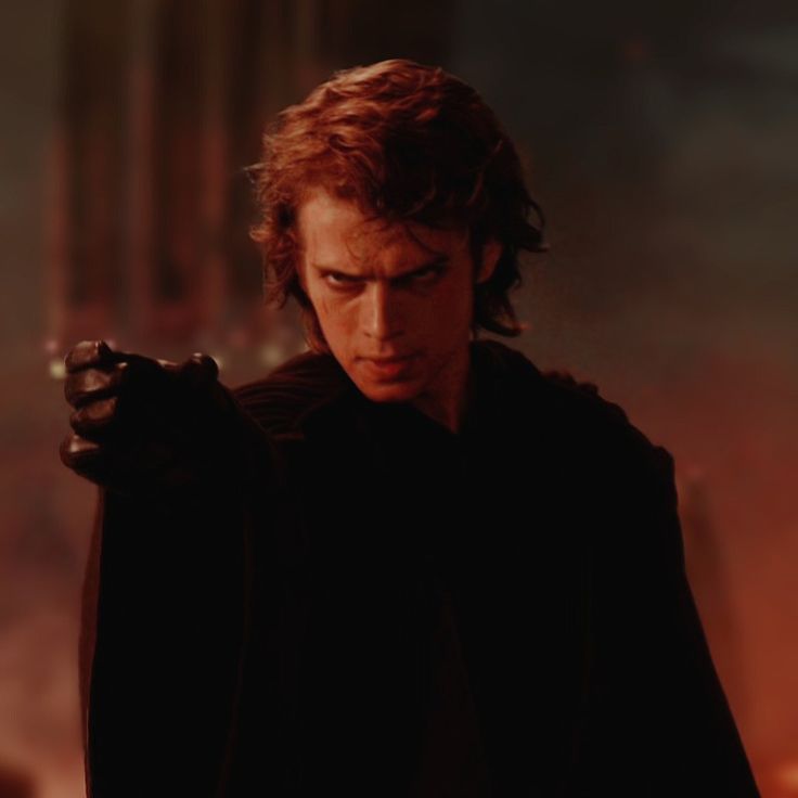 a young man dressed as darth vader pointing at something in the distance with his hand