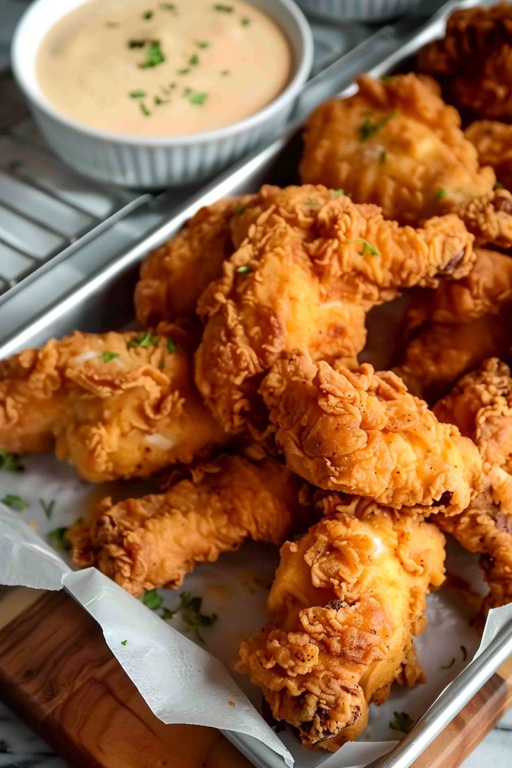 fried food items displayed on serving tray with dipping sauce