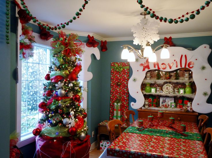 a decorated christmas tree in the corner of a room with presents on the table and other decorations