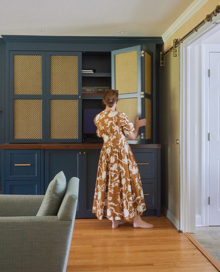 a woman standing in front of a blue cabinet