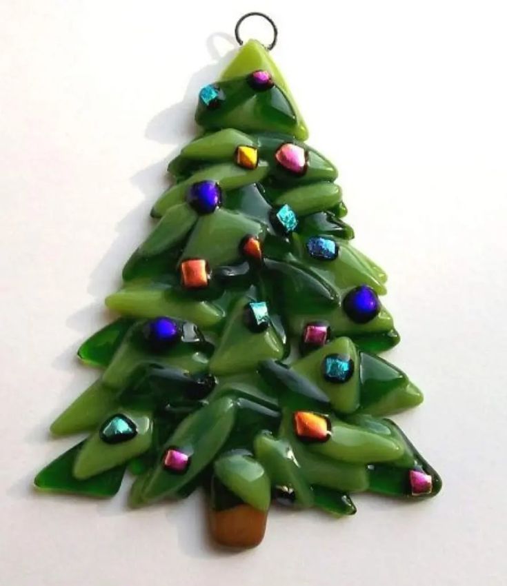 a glass christmas tree ornament hanging on a wall