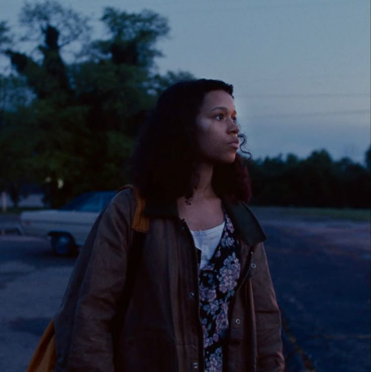 a woman walking down the street at dusk