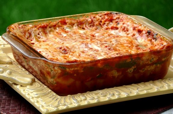 a casserole dish with meat and cheese in it sitting on a yellow plate