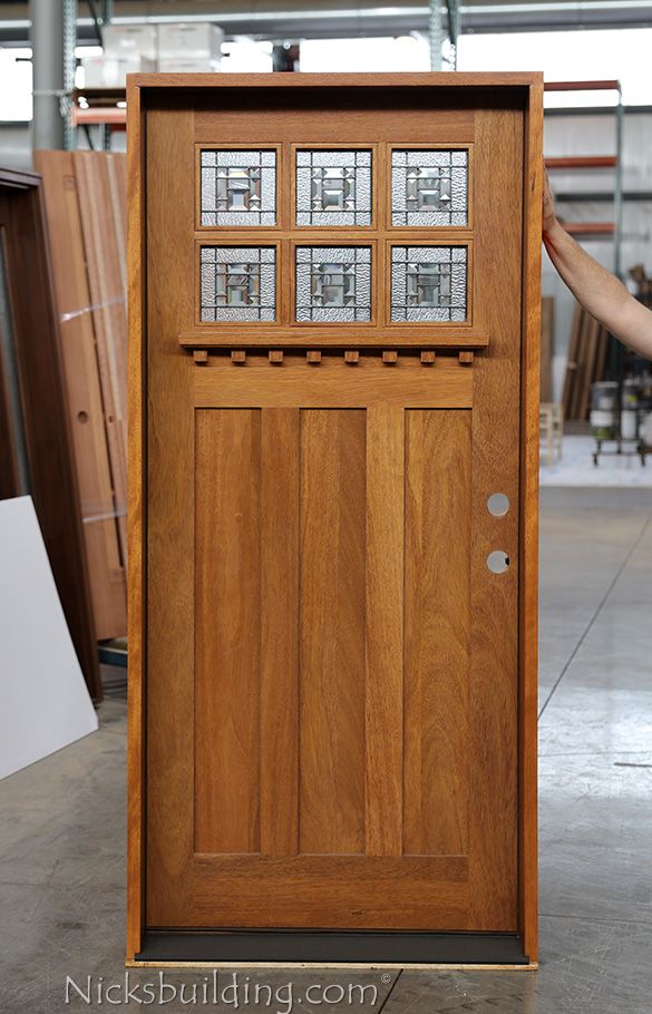 a person holding up a wooden door with glass inserts on the front and sides