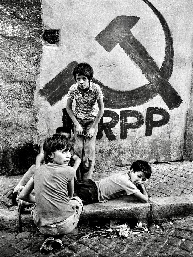 black and white photograph of children playing in front of graffiti