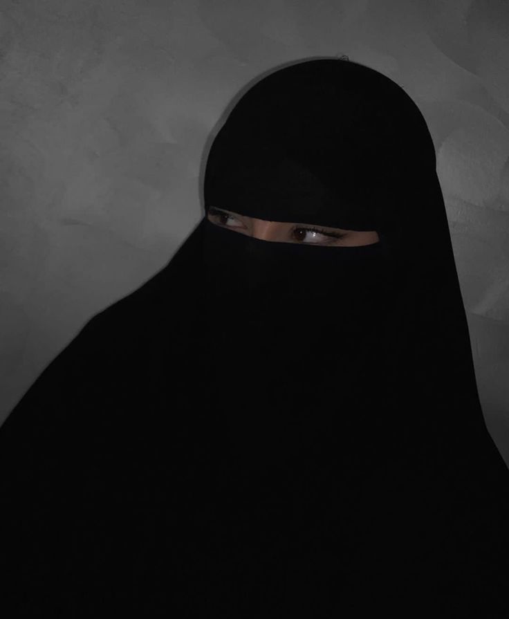 a woman wearing a black veil and looking at the camera with an intense look on her face