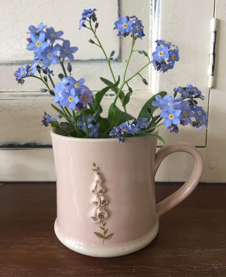 a pink mug with blue flowers in it