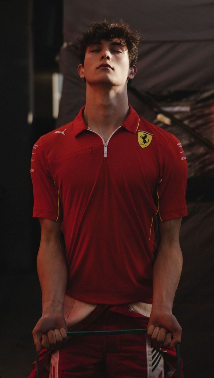 a young man in a red shirt holding a tennis racquet