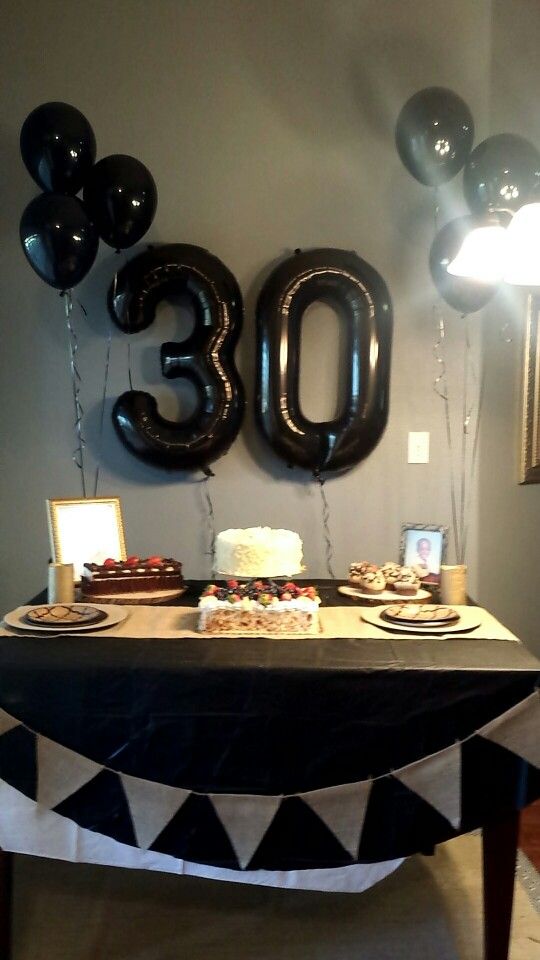 a table with balloons and cake on it in front of the number thirty three sign