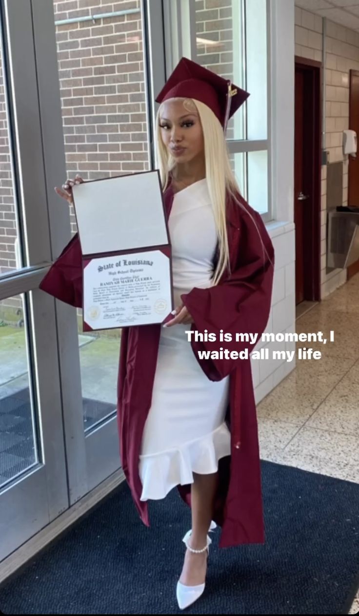 a woman in a graduation gown and cap holding a plaque that says, this is my moment i waited all my life