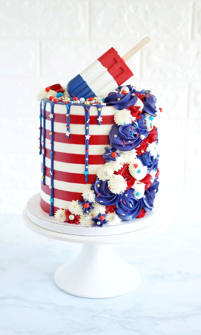 the cake is decorated with red, white and blue icing on top of it