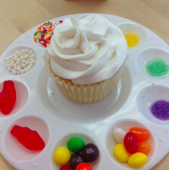 a cupcake with white frosting and candy on it