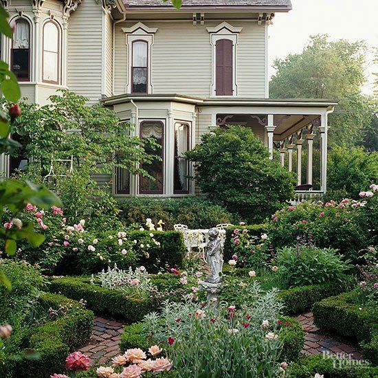 a large house with lots of flowers in the front yard and garden area next to it