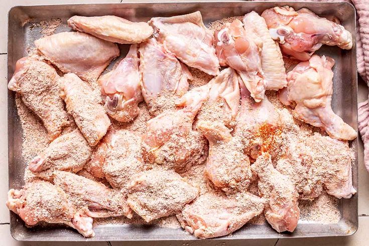 raw chicken on a baking sheet ready to be put into the oven for roasting