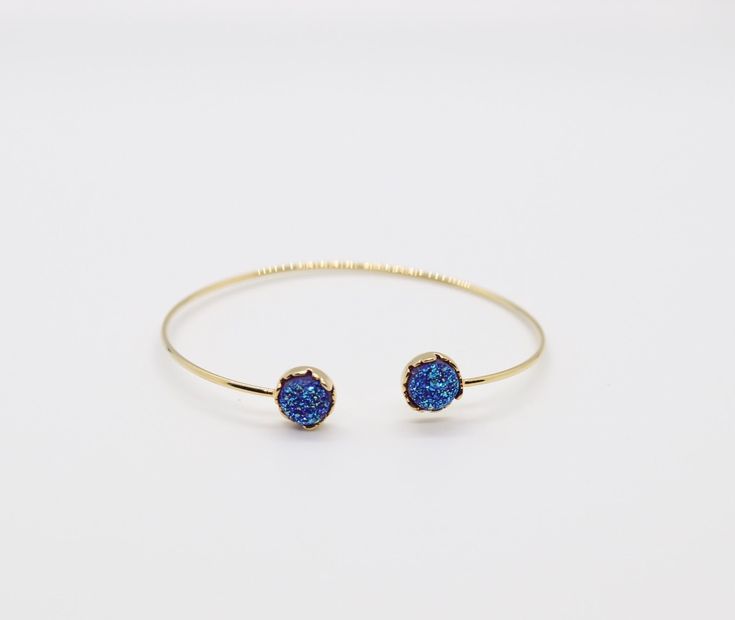 The Druzy Navy Blue Stone End Cuff Bracelet is a lightweight bracelet that is great to use for stacking with other bracelets. It is a beautiful bracelet that will add a touch of elegance to any outfit. Adjustable Blue Stackable Stretch Bracelet, Blue Adjustable Stackable Stretch Bracelet, Blue Stackable Wrap Bracelet As Gift, Adjustable Blue Stackable Wrap Bracelet, Elegant Blue Stackable Crystal Bracelet, Blue Stackable Jewelry As Gift, Elegant Blue Wrap Bracelet As Gift, Elegant Blue Wrap Bracelet As A Gift, Blue Stackable Bracelets As Gift