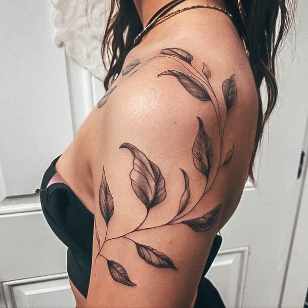 a woman's arm with leaves on it