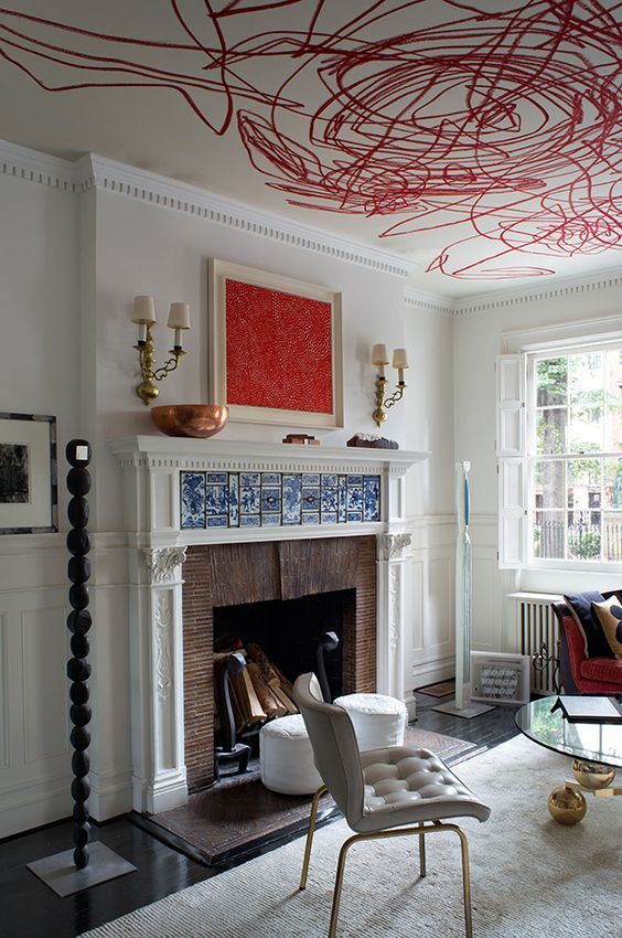 a living room filled with furniture and a fire place under a painting on the ceiling