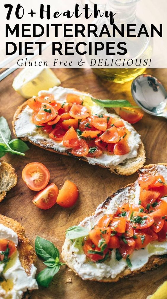 some bread with tomatoes and cheese on it next to other food items that are on a cutting board