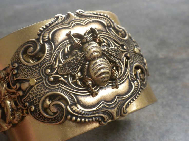 This men's wide brass bee cuff bracelet is a one of a kind piece made with vintage decorative banding layered on a men's size brass cuff.  The bee is securely wired to a decorative stamping, and the stamping is bolted securely to the banding and cuff.  The brass is a rich oxidized patina professionally sealed. It is lined on the backside with leather for comfort. Here is a link to the other men's cuffs in my shop. https://www.etsy.com/shop/Serrelynda?ref=seller-platform-mcnav&section_id=45747499 Honey Bee Jewelry, Statement Cuff Bracelet, Honey Bee Hives, Clover Jewelry, Brass Cuff Bracelet, Good Luck Bracelet, Dragonfly Jewelry, Hippy Chic, Spring Valley