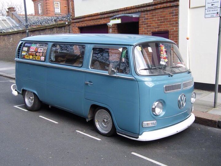 an old blue van is parked on the side of the road