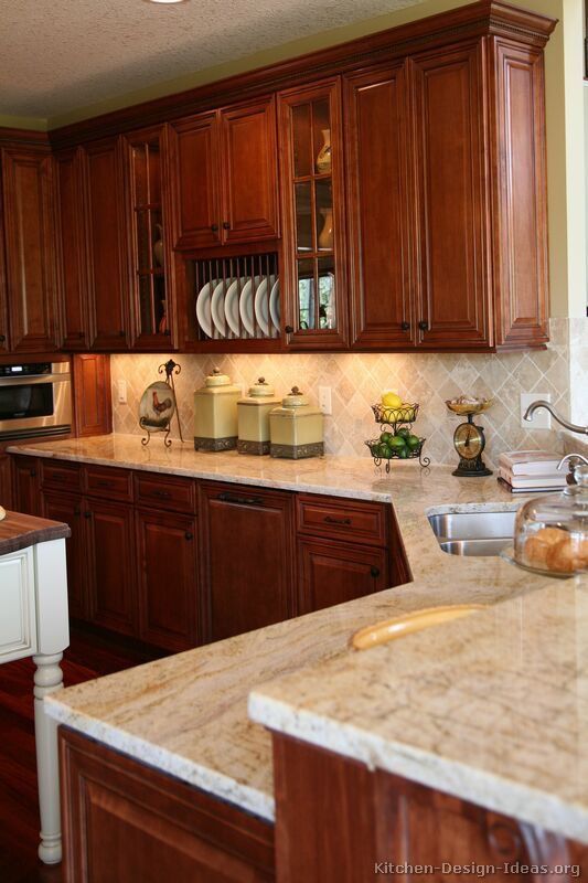 a kitchen with wooden cabinets and marble counter tops