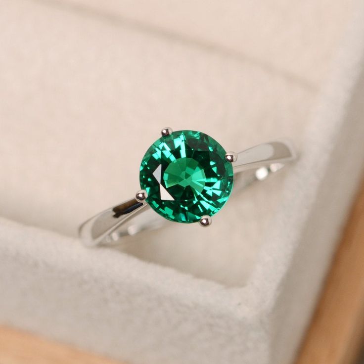 This ring features a 8mm round cut lab emerald and sterling silver finished with rhodium. Customization is available. It is made by hand, and it will take about 7 days to finish the ring after your payment is completed. Main stone: lab emerald Main stone weight: Approx 1.70 ct Metal type: sterling silver finished with rhodium Accent stone: cz Customization is available, I also can make it with 14k solid gold (white or yellow or rose) and diamond accent stone, just feel free to contact me. Any qu Emerald Green Ring, Green Emerald Ring, Green Ring, Emerald Wedding, Topaz Engagement Ring, Diamond Solitaire Engagement Ring, Emerald Gemstone, Green Emerald, Emerald Ring