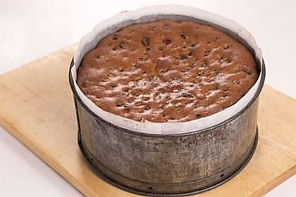 a cake in a tin sitting on top of a wooden board