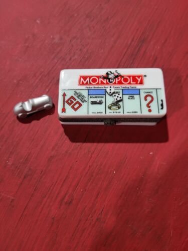 a monopoly game sitting on top of a red table next to a screwdriver