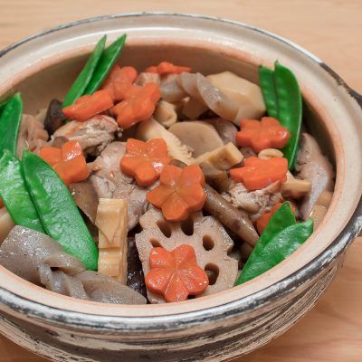 a bowl filled with vegetables and meat on top of a wooden table