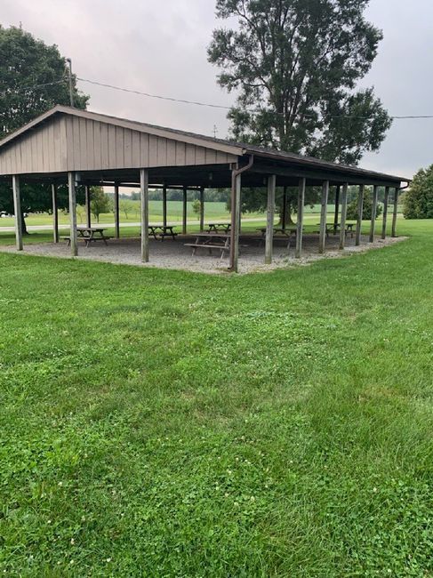 an empty picnic pavilion in the middle of a field