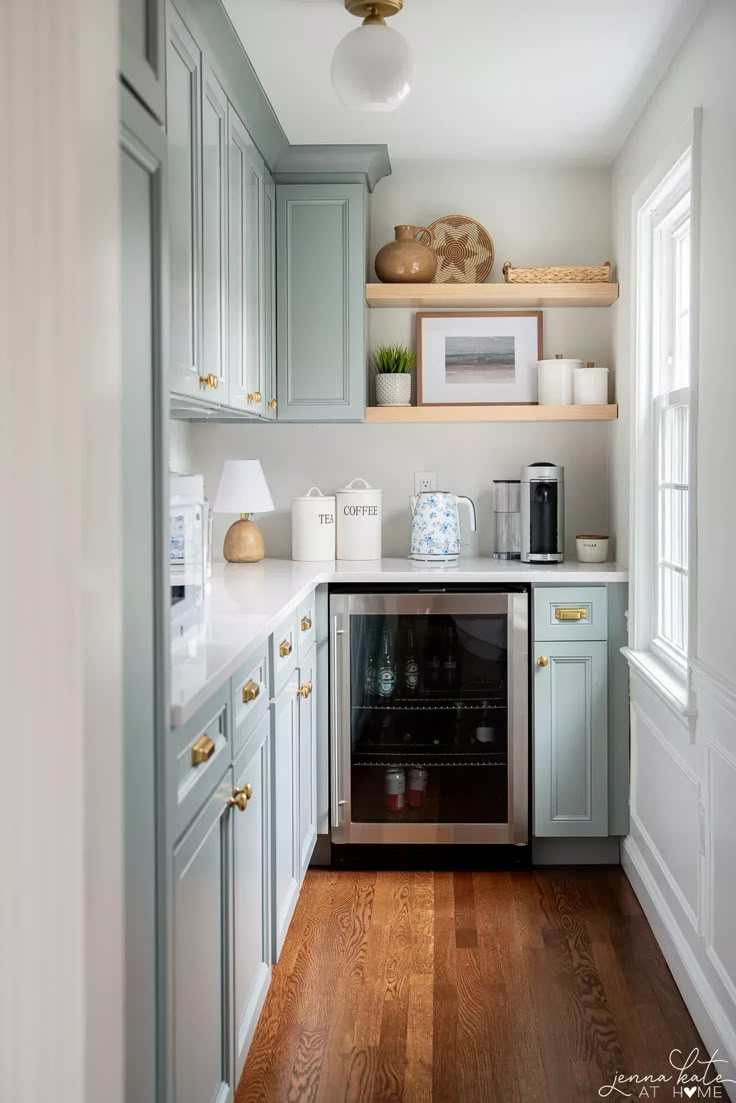 a kitchen with blue cabinets and white counter tops is shown in this image from the doorway